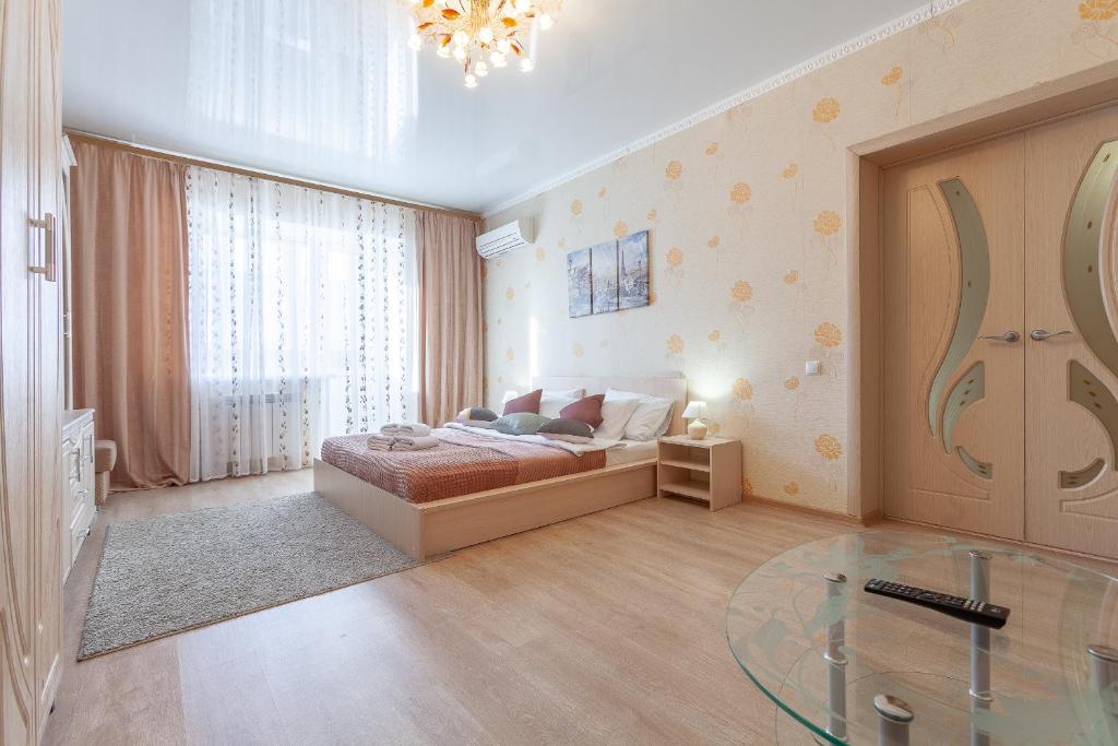 1 dormitorio con cama y mesa de cristal en Апартаменты RentPlaza-вид на жигулевские горы и волгу-15 этаж-24x7-дистанционно en Samara