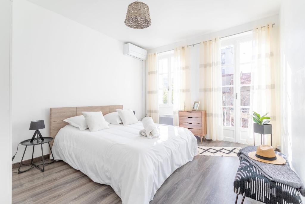 a white bedroom with a large white bed and windows at La Maison de Famille 3 chambres 8 pers Terrasse Parking Clim in Marseille