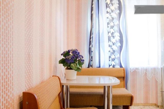 a table with a vase of flowers on top of it at Comfort.Arenda Minsk in Minsk