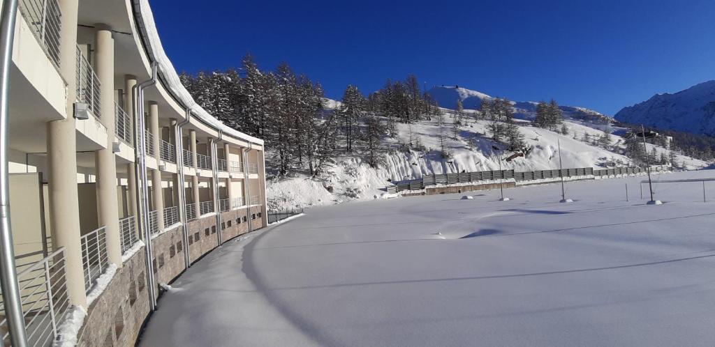 a building with snow on the side of a mountain at Hotel Lago Losetta in Sestriere