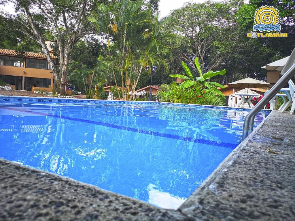 Cotlamani Hotel Aventura في Jalcomulco: مسبح ازرق كبير بجانب منتجع