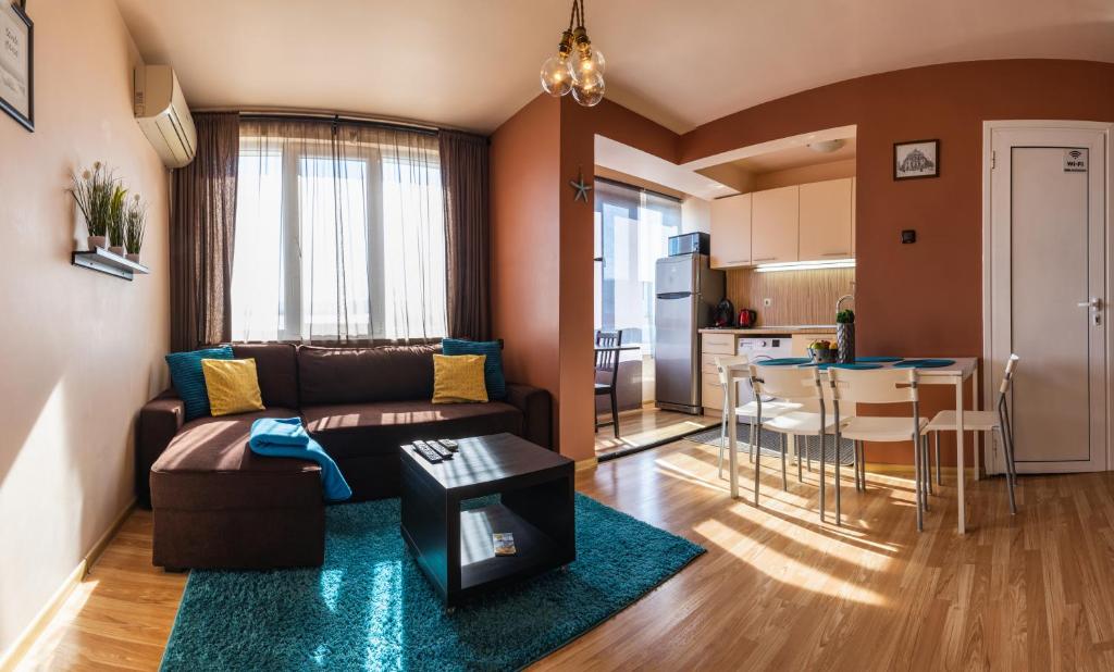 een woonkamer met een bank en een tafel en een keuken bij LunApart in Varna