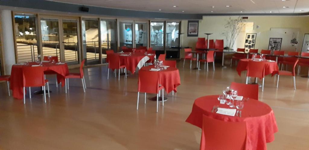 a dining room with red tables and chairs at Hotel Lago Losetta in Sestriere