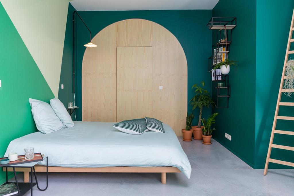 a bedroom with a bed and a green wall at Boutique B&B Graaf in Ghent