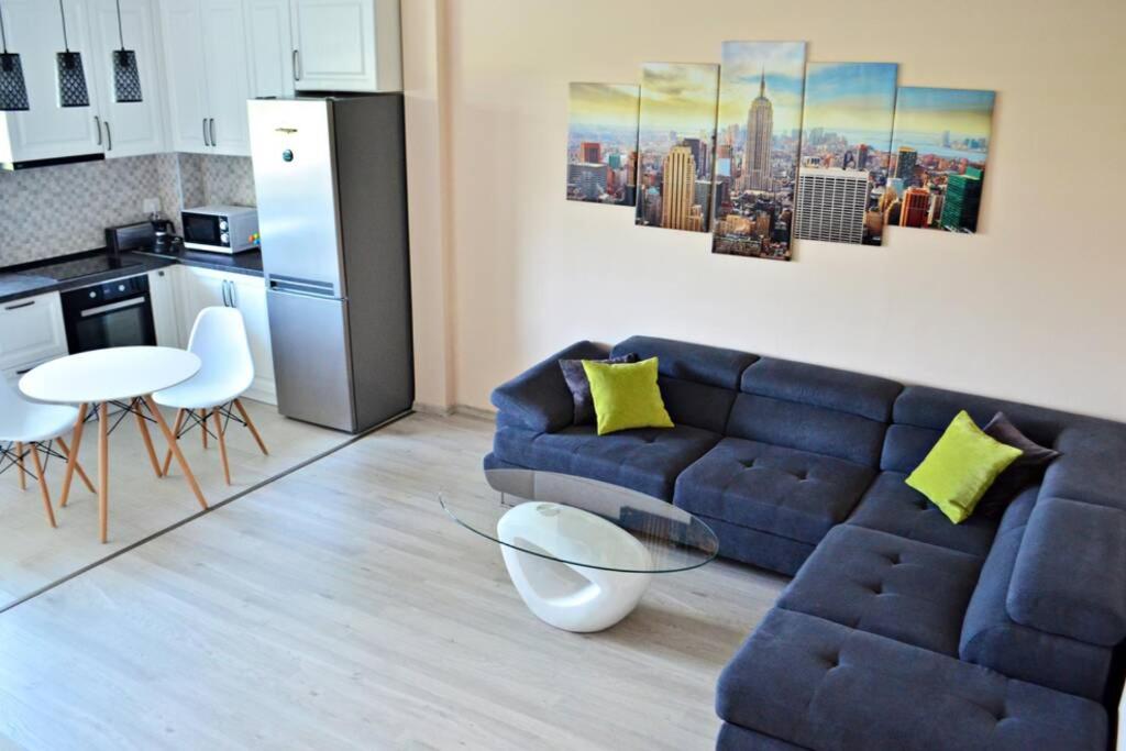 un soggiorno con divano blu e una cucina di M&M Apartment a Oradea