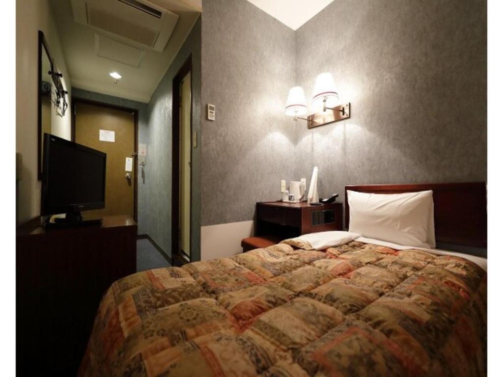 1 dormitorio con 1 cama grande y TV en Tokyo Inn - Vacation STAY 10232v, en Tokio