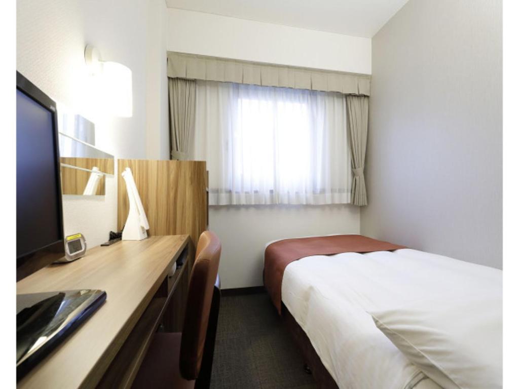 a hotel room with a bed and a desk with a television at Tokyo Inn - Vacation STAY 10241v in Tokyo