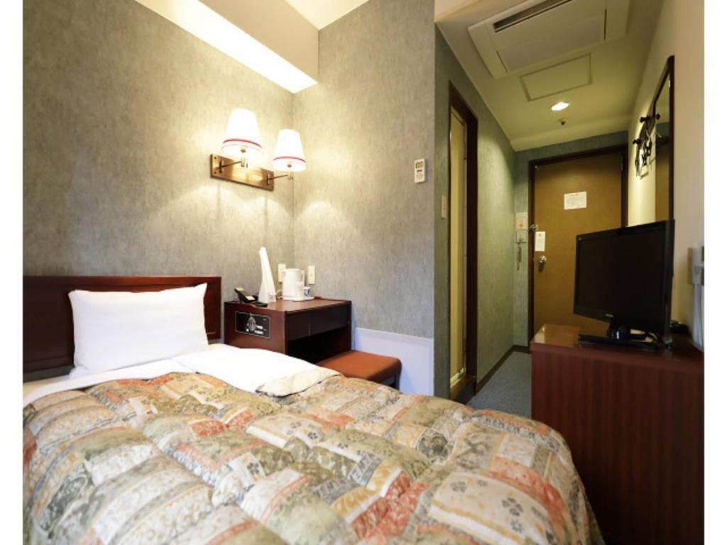 a hotel room with a bed and a flat screen tv at Tokyo Inn - Vacation STAY 10227v in Tokyo