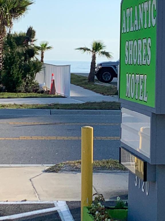 una señal para un hotel en un estacionamiento en Atlantic Shores Motel en Daytona Beach