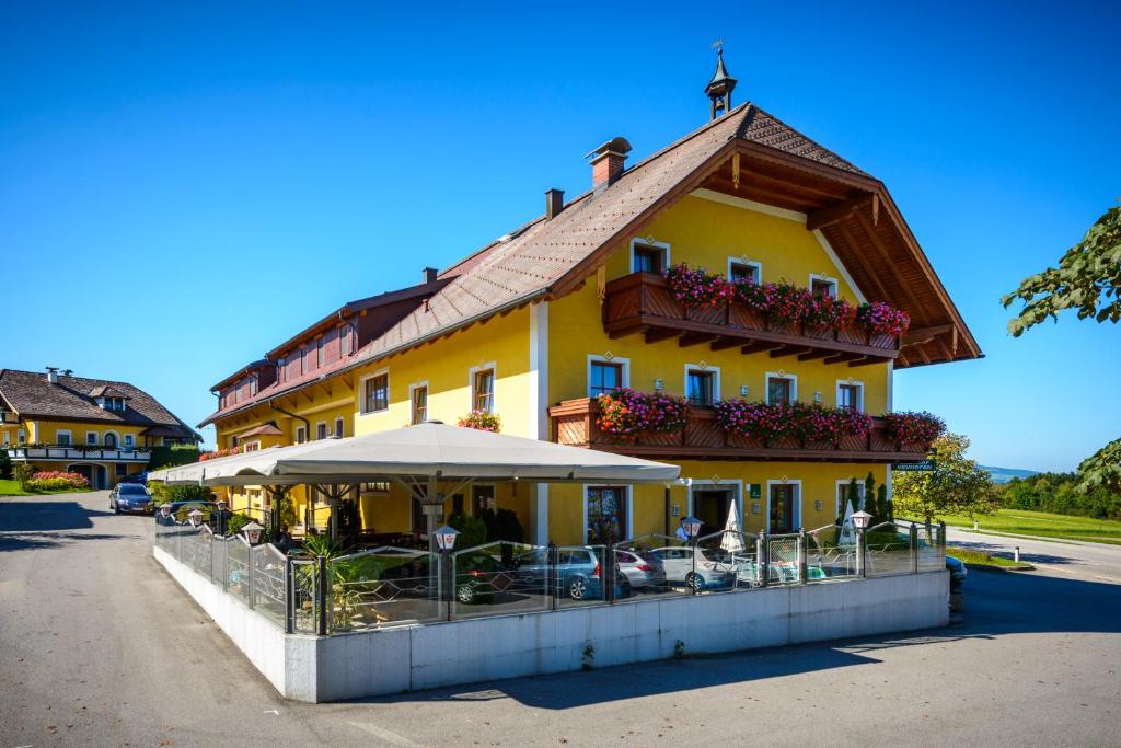 a large yellow building with a roof at Gasthof Neuhofen in Eugendorf