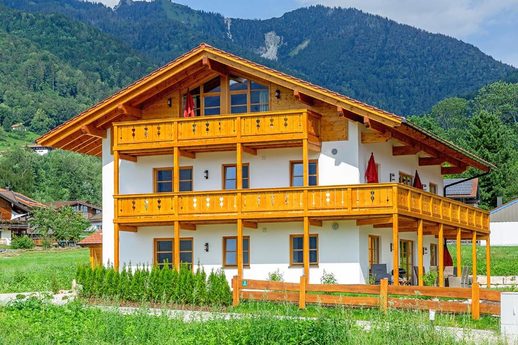 a large wooden house with a balcony on top at Chiemgauferienwohnungen - Maier in Unterwössen