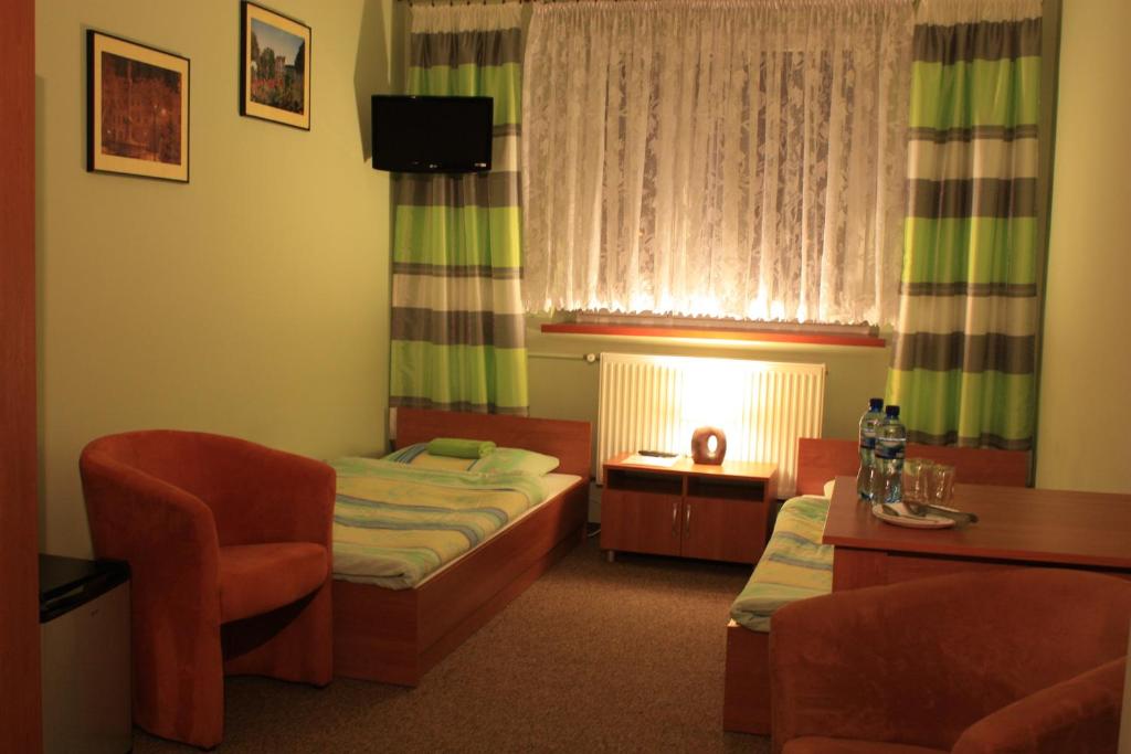 Habitación de hotel con cama y silla en Moravia, en Krzanowice