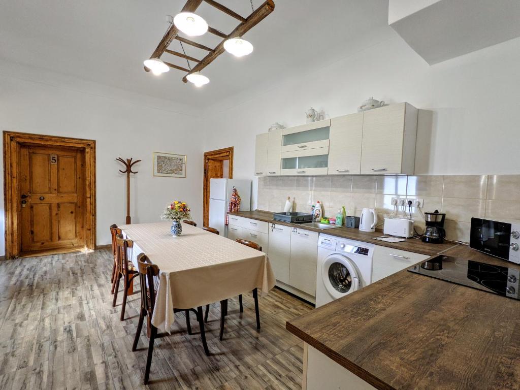 a kitchen with a table and a kitchen with white cabinets at Gästehaus Honigberg next to the Fortified Church of Harman in Hărman