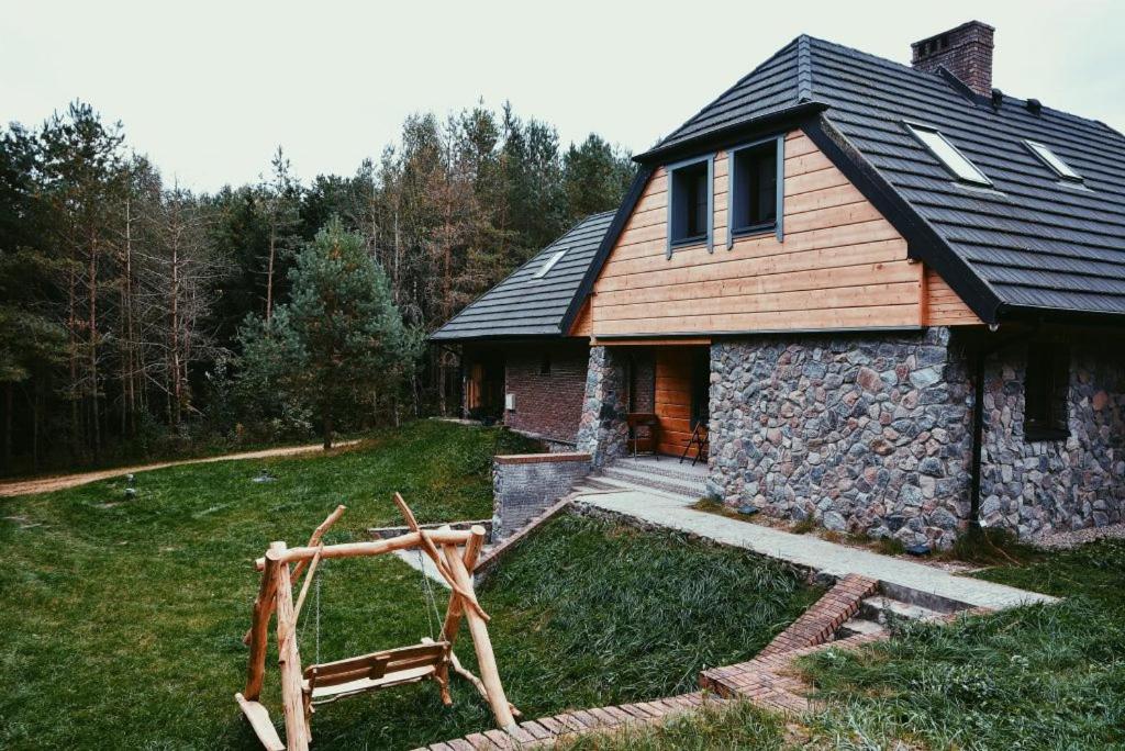 a stone house with a gambrel roof and a yard at Lawendowe Siedlisko in Suwałki