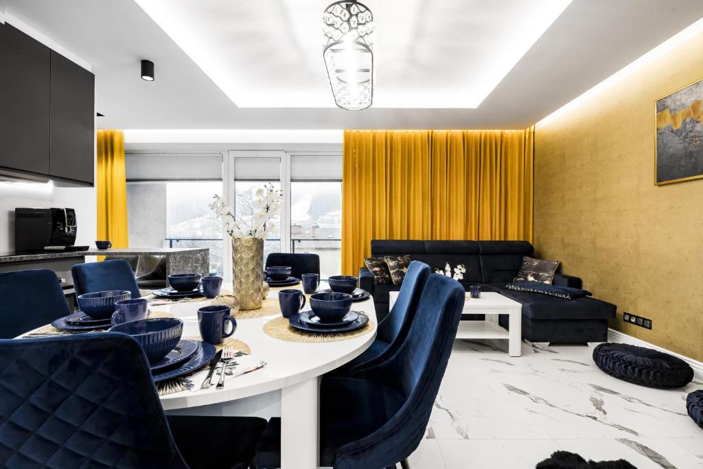 Apartament Zacisze z prywatną sauną في شتوروك: غرفة طعام مع طاولة وكراسي زرقاء