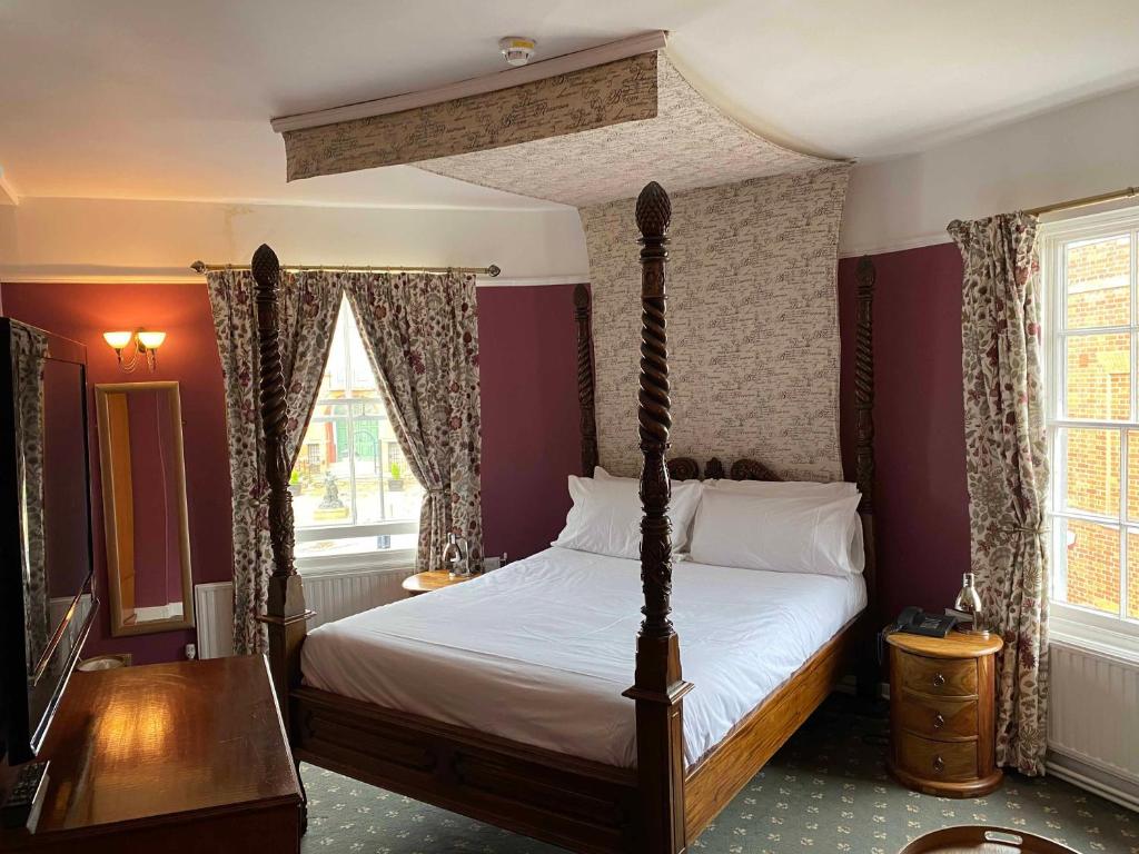 ウッドブリッジにあるThe Bull Innのベッドルーム1室(天蓋付きベッド1台、テーブル、窓付)