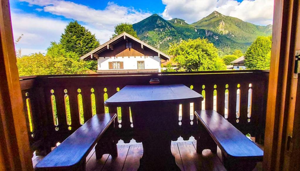 eine Veranda mit einem Tisch und Bänken auf einem Balkon in der Unterkunft Ferienwohnung Reisenauer in Marquartstein