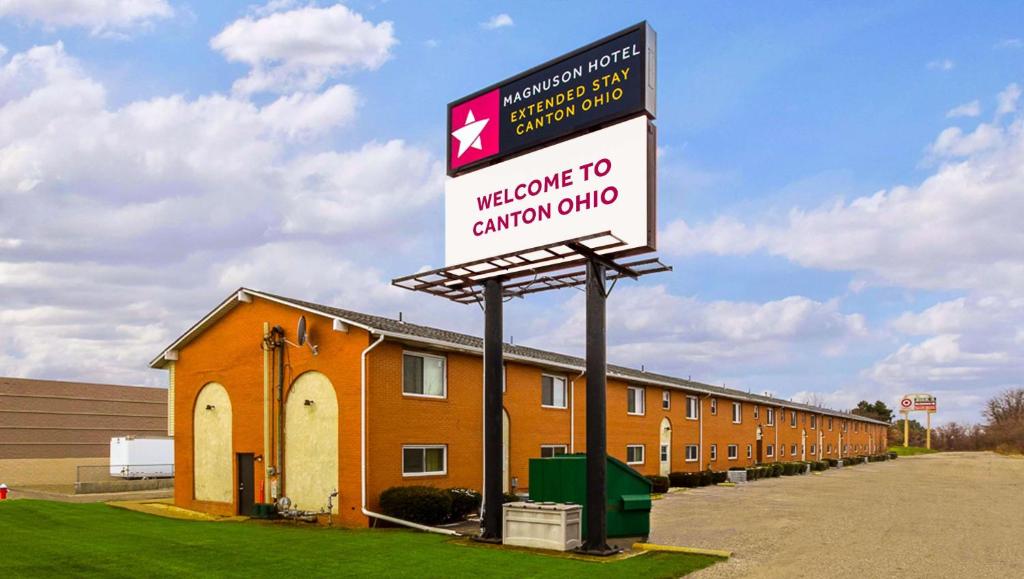 una bienvenida a la señal del club canadiense frente a un edificio en Magnuson Hotel Extended Stay Canton Ohio, en Lake Cable
