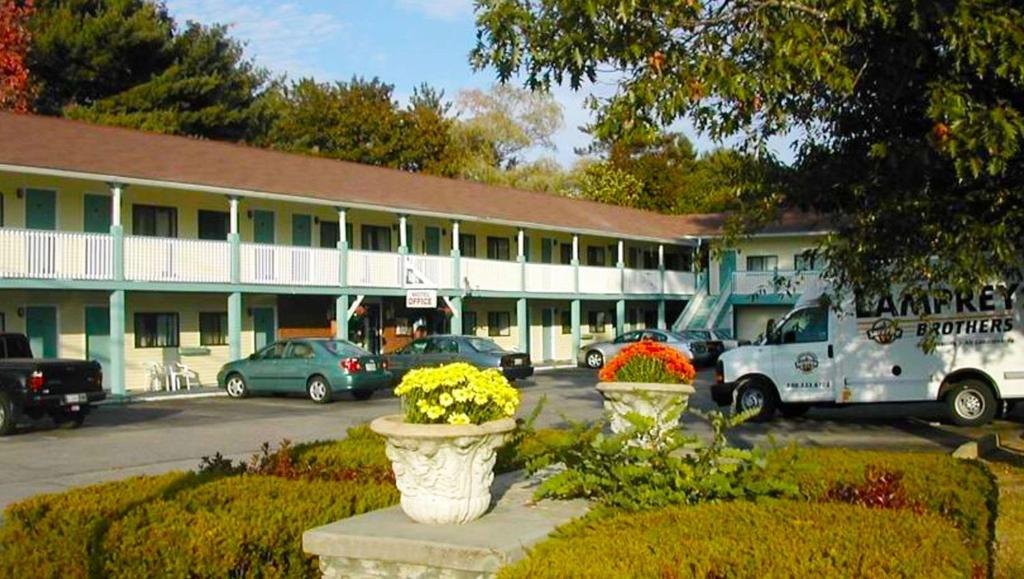 ein Gebäude mit Autos auf einem Parkplatz in der Unterkunft Hampton Motor Inn in Hampton