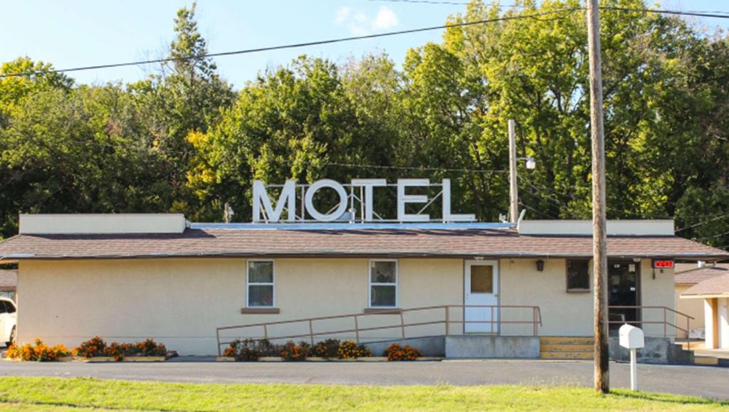una señal de motel en la parte superior de un edificio en Golden Wheat Budget Host Inn Junction City, en Junction City