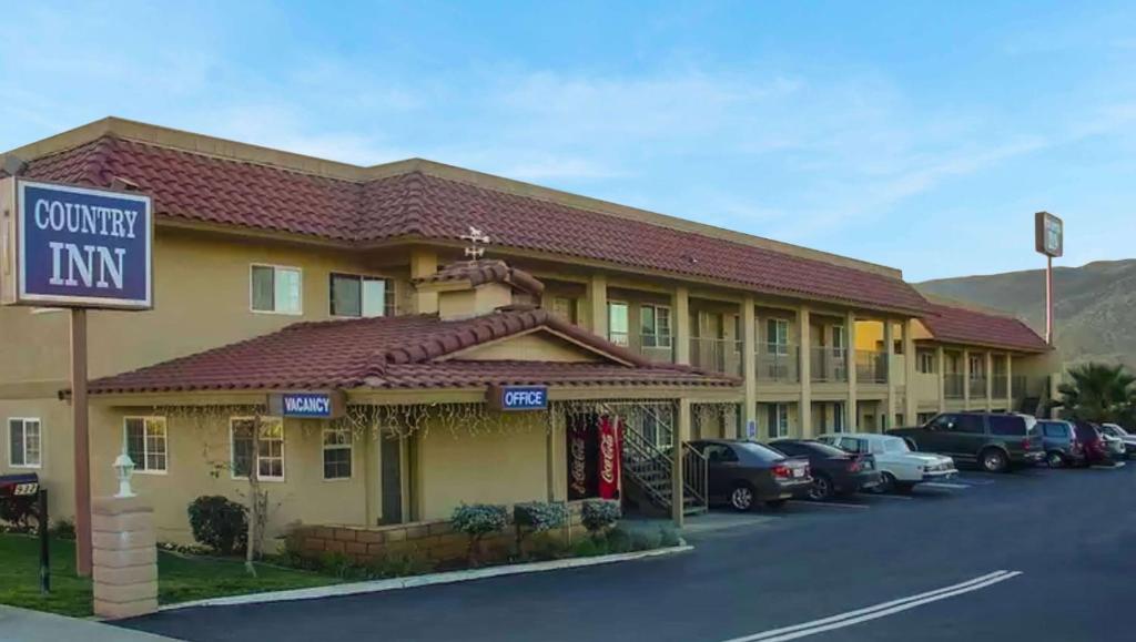 un hotel con coches estacionados en un estacionamiento en Country Inn Banning, en Banning