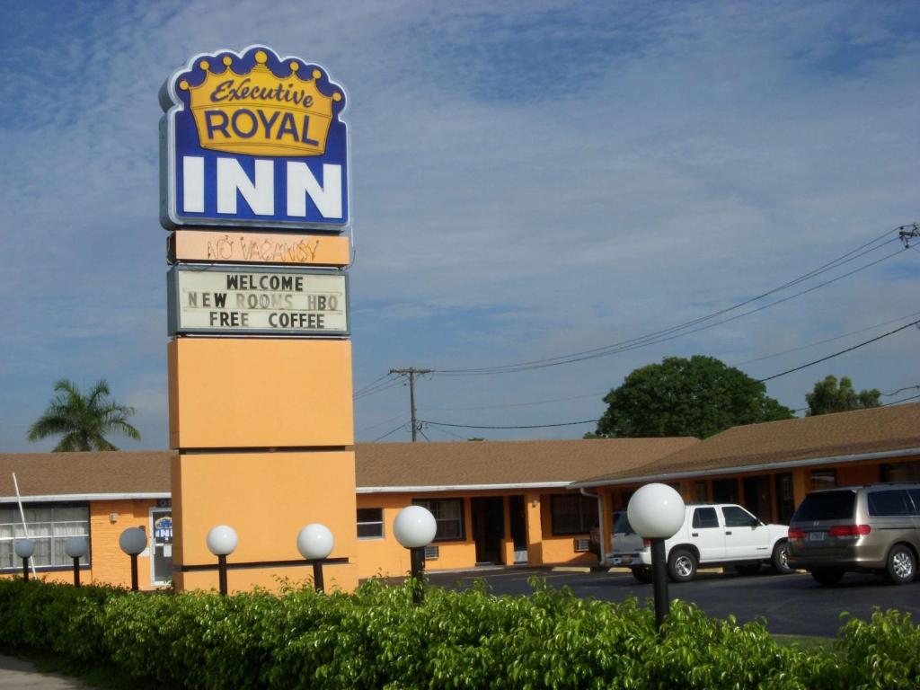 una señal para una posada real en un estacionamiento en Executive Royal Inn Clewiston, en Clewiston