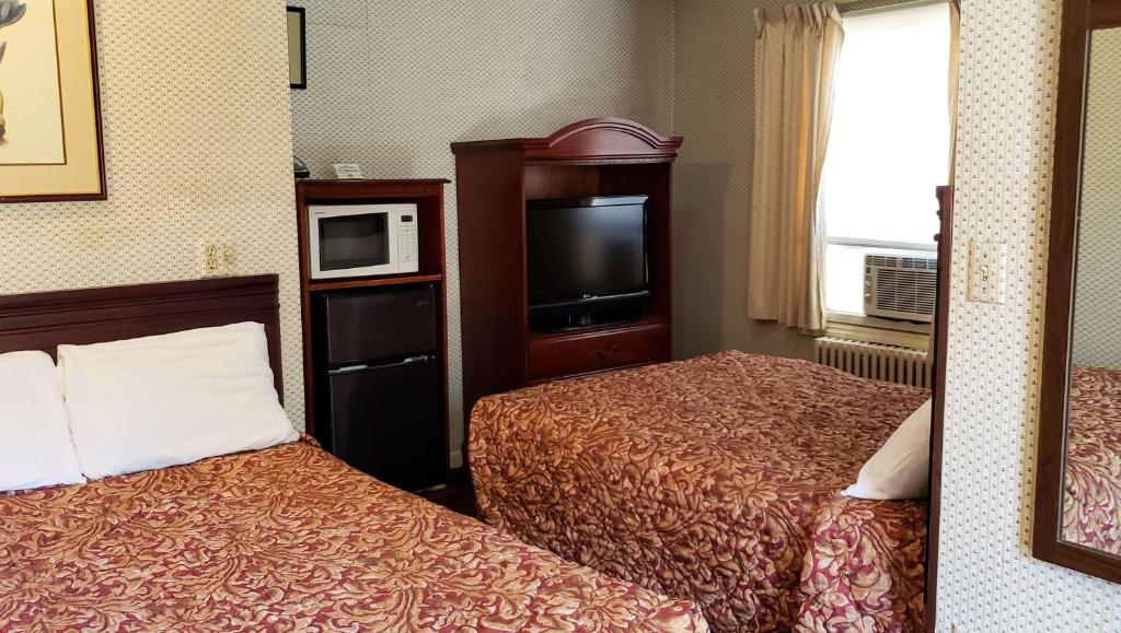 a hotel room with two beds and a television at Windmill Inn Lynden in Lynden