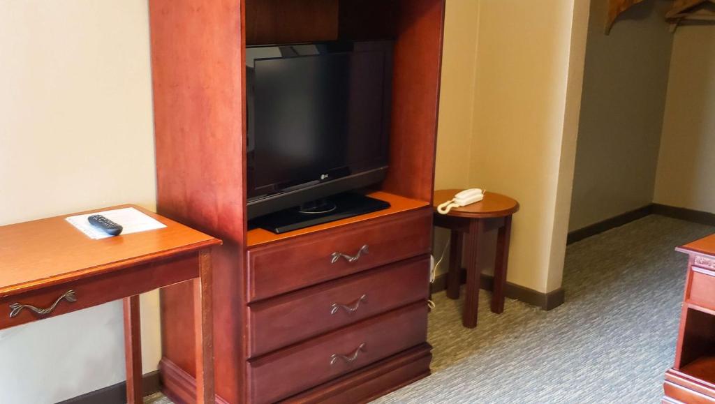 a hotel room with a tv and a dresser at Windmill Inn Lynden in Lynden