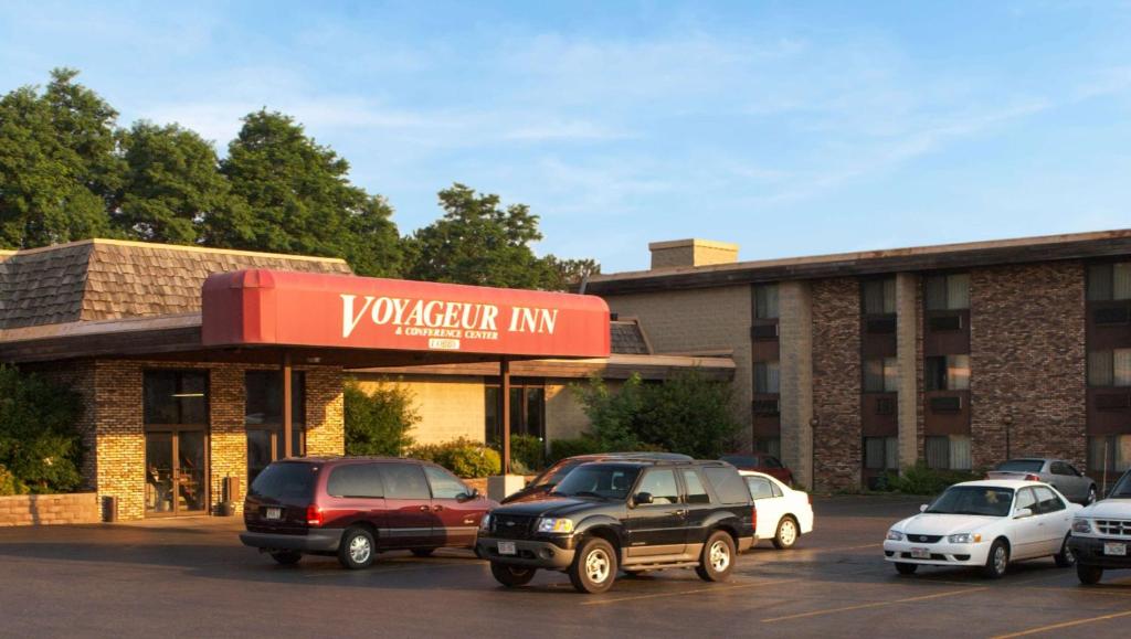una posada vaughan con coches aparcados en un aparcamiento en Voyageur Inn and Conference Center, en Reedsburg