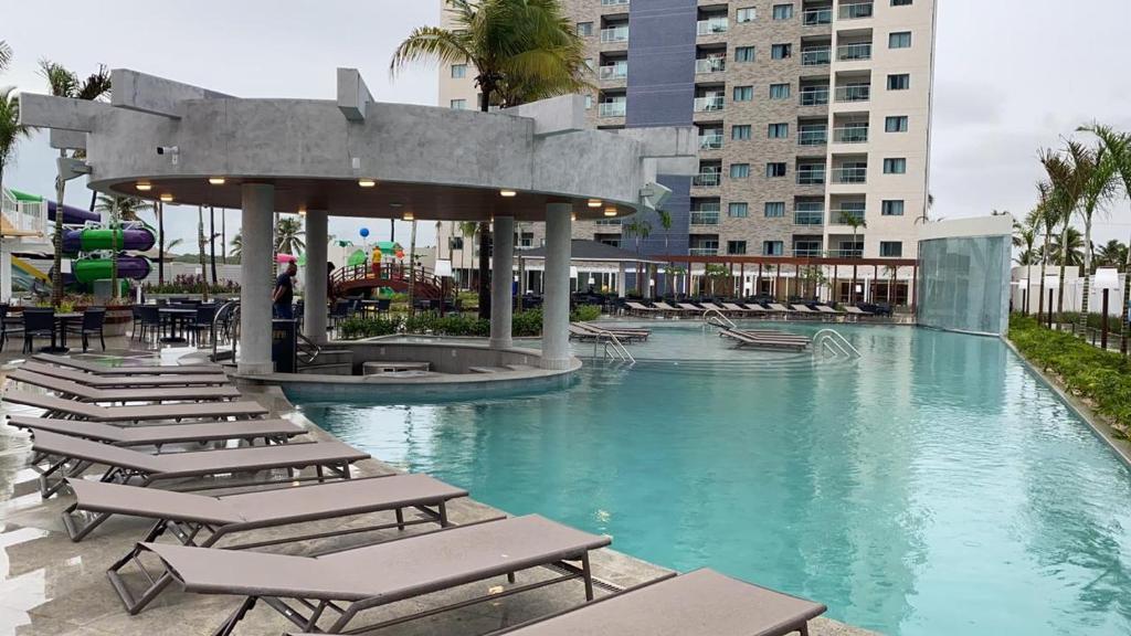 - une piscine avec des chaises longues dans un complexe dans l'établissement SALINAS EXCLUSIVE RESORT, à Salinópolis