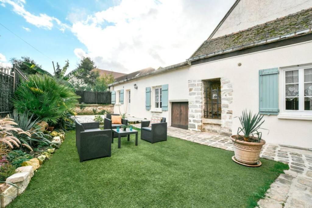 una imagen de un jardín con muebles y césped en INSTANT FLEURY: maison de caractère, jardin secret, en Barbizon