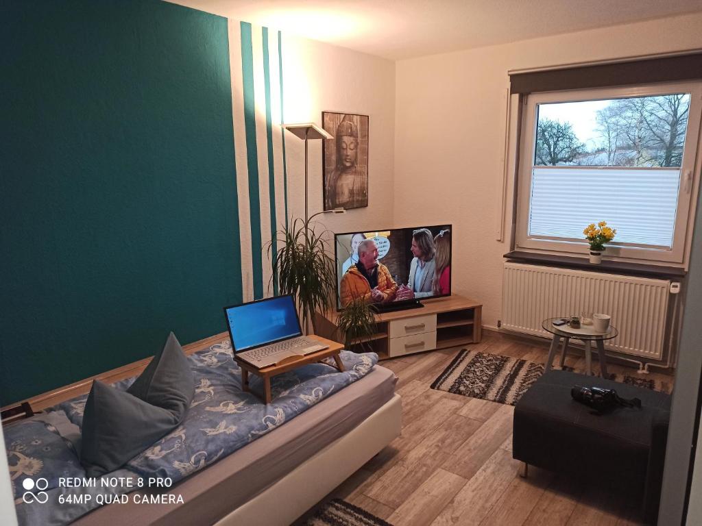 sala de estar con sofá y ordenador portátil. en Ferienwohnung "An der Geest 1", en Buxtehude