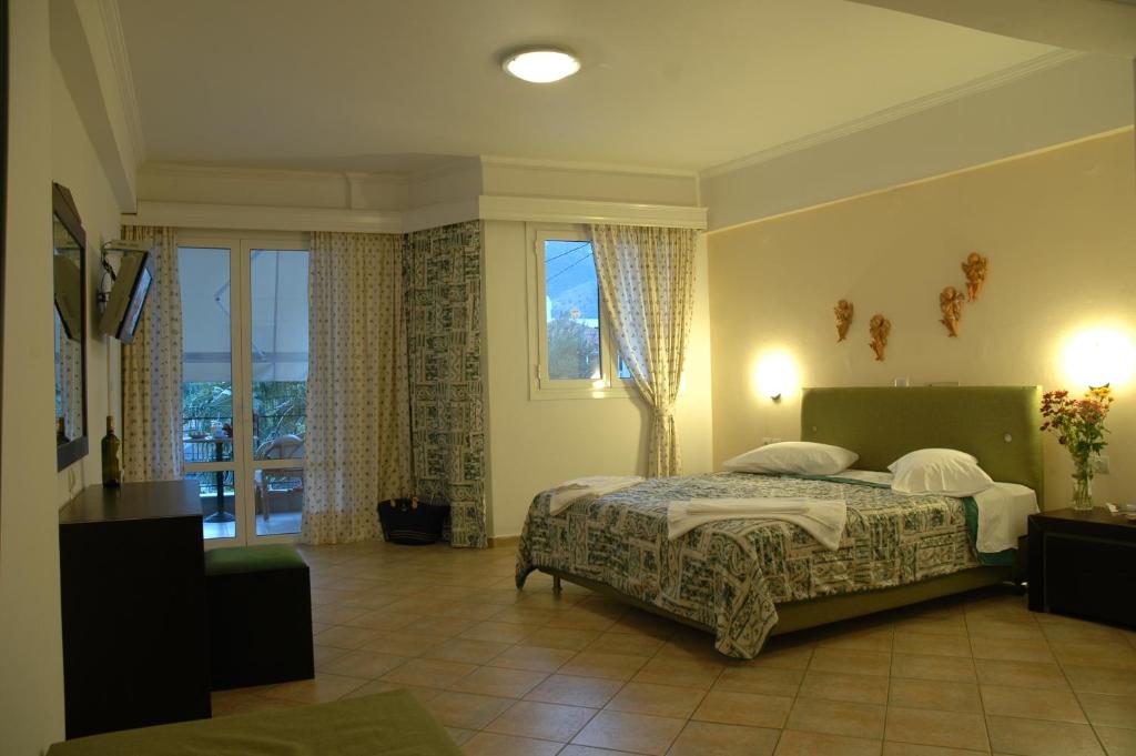 a bedroom with a bed and a large window at Santa Maura in Nydri
