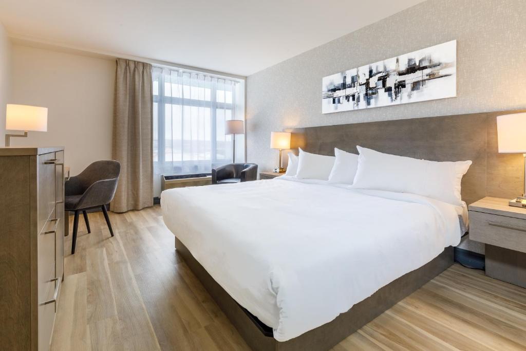 uma grande cama branca num quarto de hotel em Repotel Henri IV Québec em Cidade de Quebec