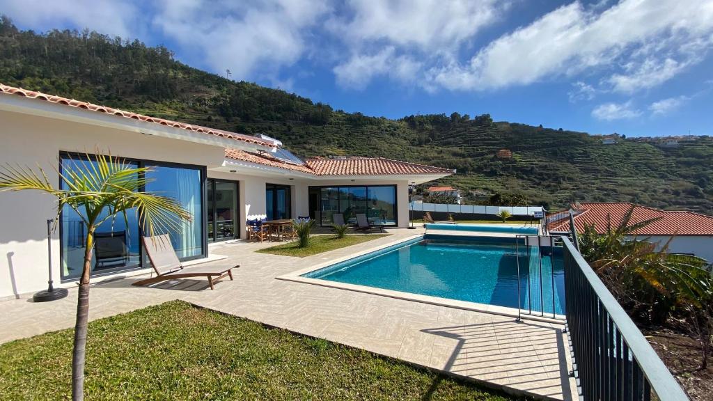 uma villa com uma piscina e uma montanha em Villa Palheiros em Arco da Calheta