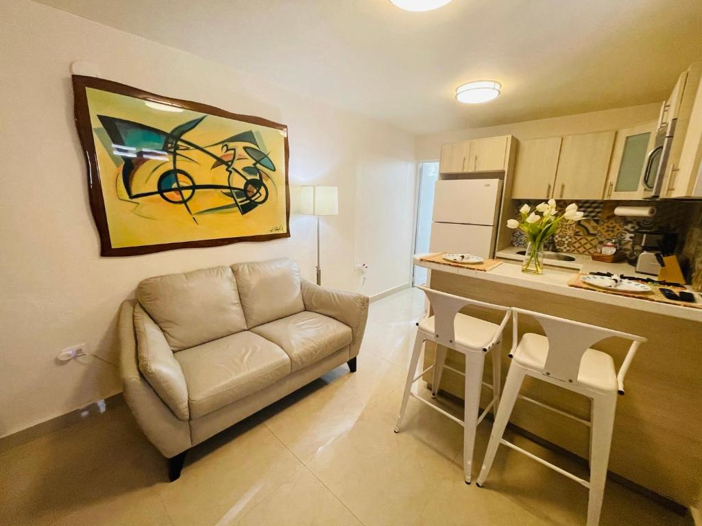 a living room with a couch and a table and a kitchen at Compact Haven with Private Entrance and FREE Parking and Laundry in Ponce