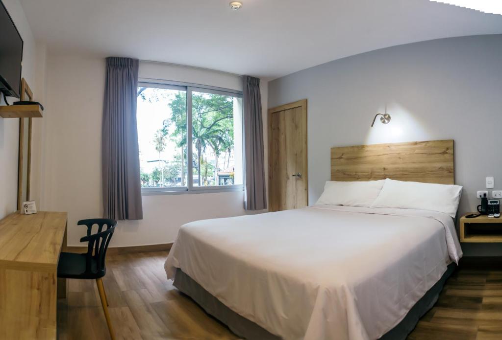Un dormitorio con una cama grande y una ventana en The Park Hotel en Guayaquil