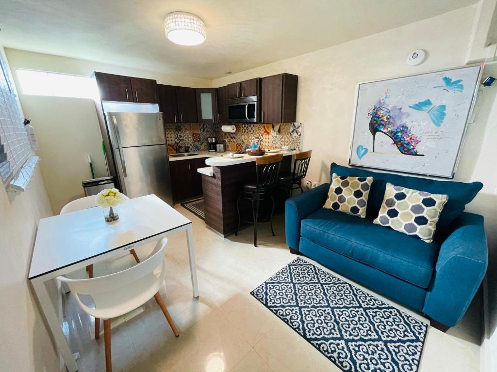a living room with a blue couch and a kitchen at Charming Retreat with Patio Access in Ponce