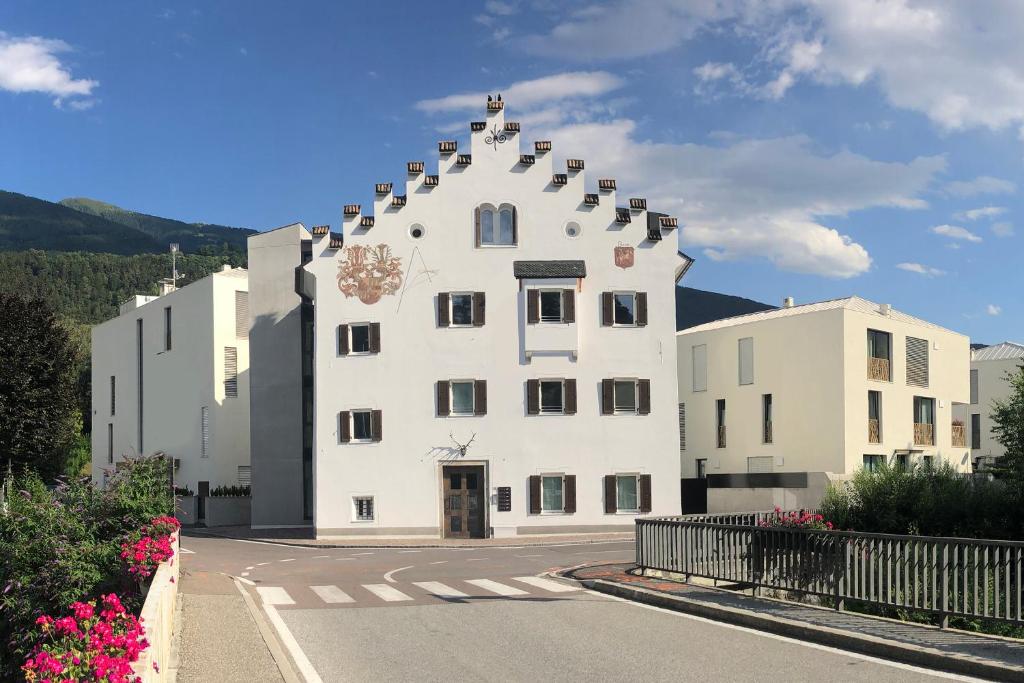 a large white building with a pointed roof at Apartments Griesser in Bressanone