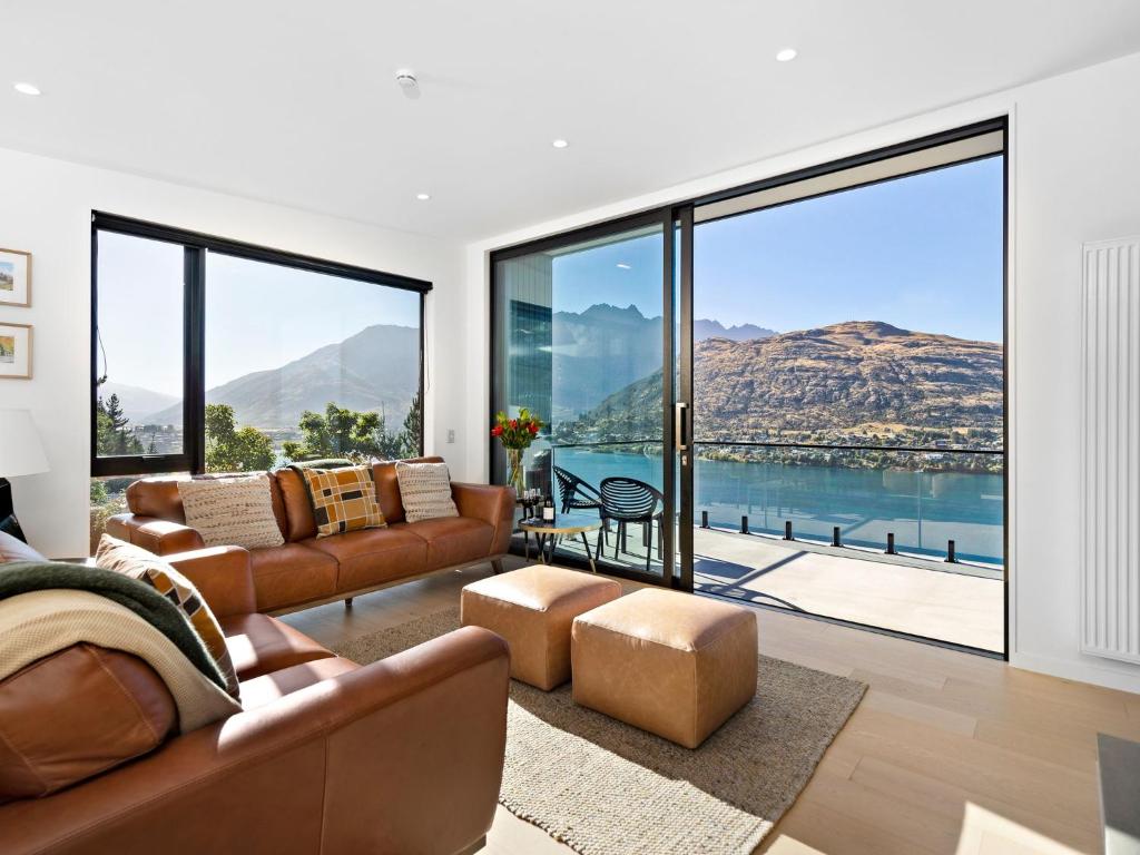 a living room with couches and a view of the water at Woods Villa Tui in Queenstown