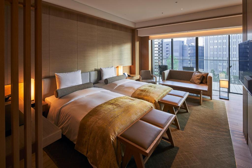 um quarto com uma cama grande e uma janela grande em The Okura Heritage Tokyo em Tóquio