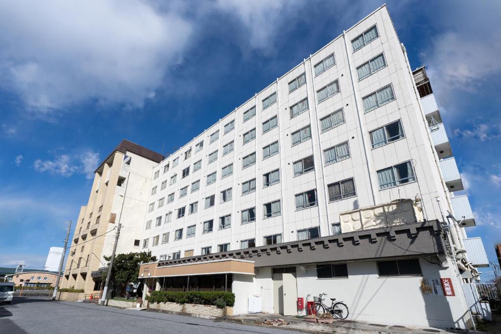 a large white building on a city street at Tabist Hotel Ginga Kisarazu in Kisarazu