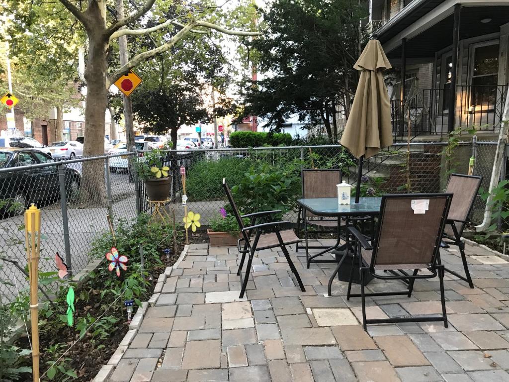 a patio with a table and chairs and an umbrella at Classical American House 3 in Brooklyn