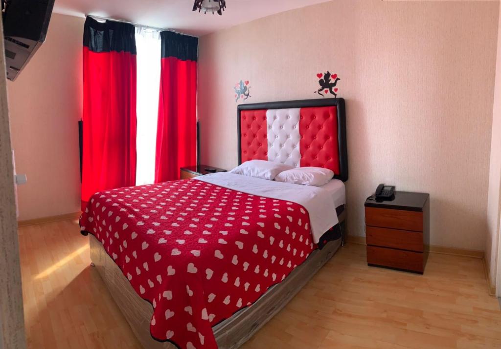 a bedroom with a red and white bed with red curtains at Peruvian Apartment in Lima