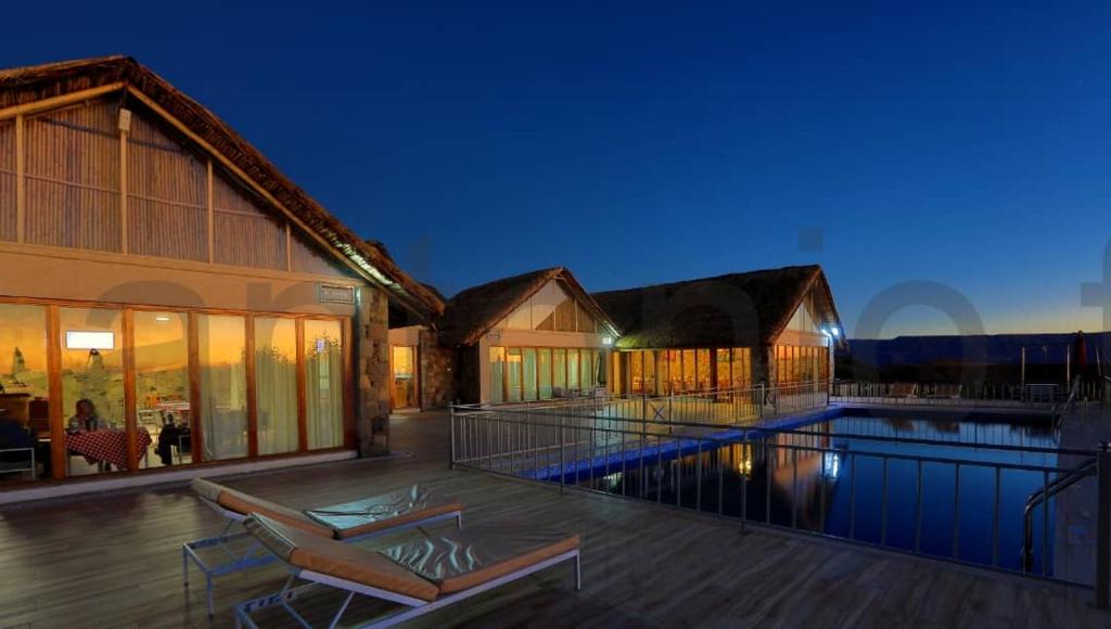 a house with a swimming pool in front of a building at Mezena Resort & SPA in Lalībela