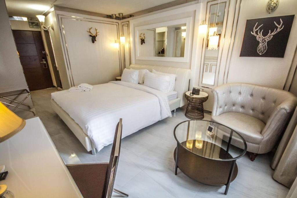 a hotel room with a bed and a chair and a table at R1 Nimman Hotel Chiangmai in Chiang Mai