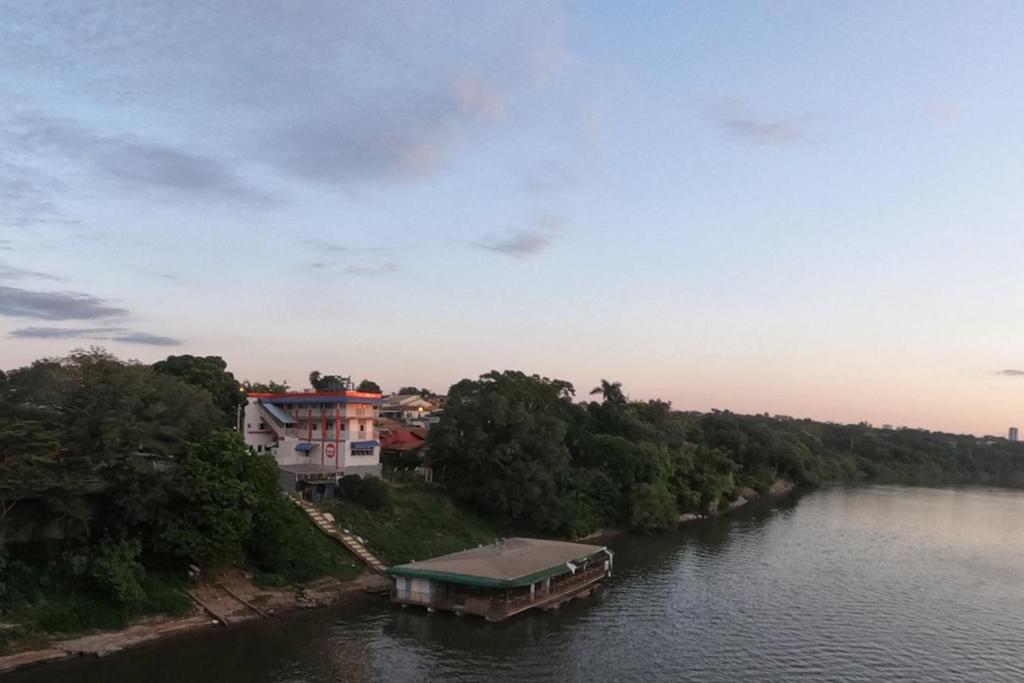 Un río con una casa y un barco en el agua en Lord Hotel, en Várzea Grande