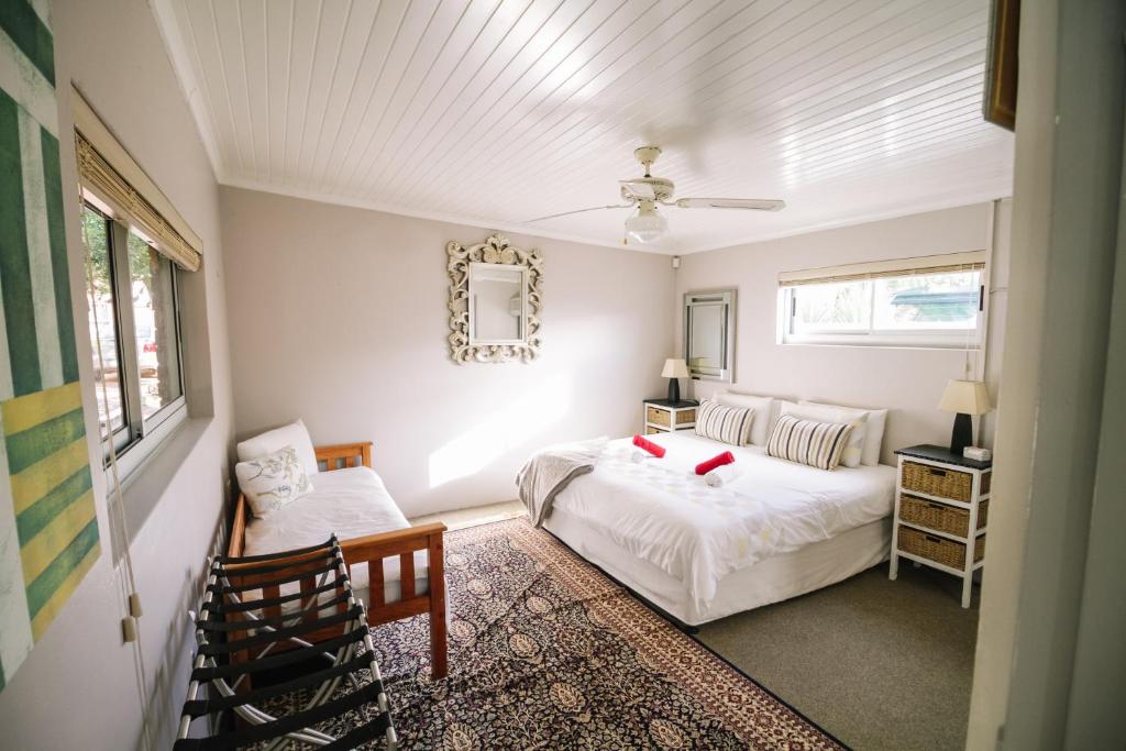 a bedroom with a bed and a chair at 90 On Wellington Cottage in Port Elizabeth