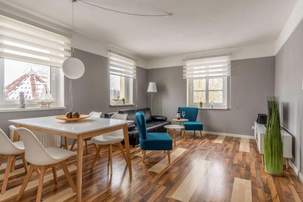 ein Esszimmer und ein Wohnzimmer mit Tisch und Stühlen in der Unterkunft Haus Godewind Typ 4 in Binz