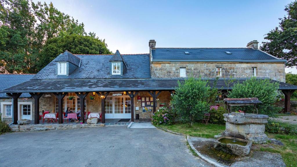 - une vue sur l'extérieur d'une grande maison en pierre dans l'établissement Auberge De Kerveoc'h, à Douarnenez